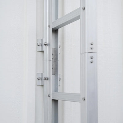 Fastmontert rømningsstige i aluminium på hvit vegg, for brannsikkerhet og evakuering.