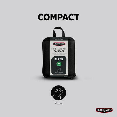 Kompakt førstehjelpsskrin med 32 deler for små sår, sort veske mot grå bakgrunn.